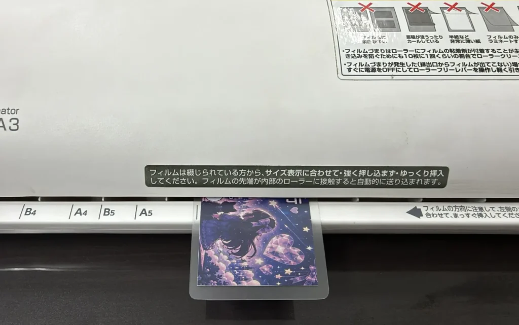 パパノ銀行のキャッシュカードをラミネーターで加工している様子